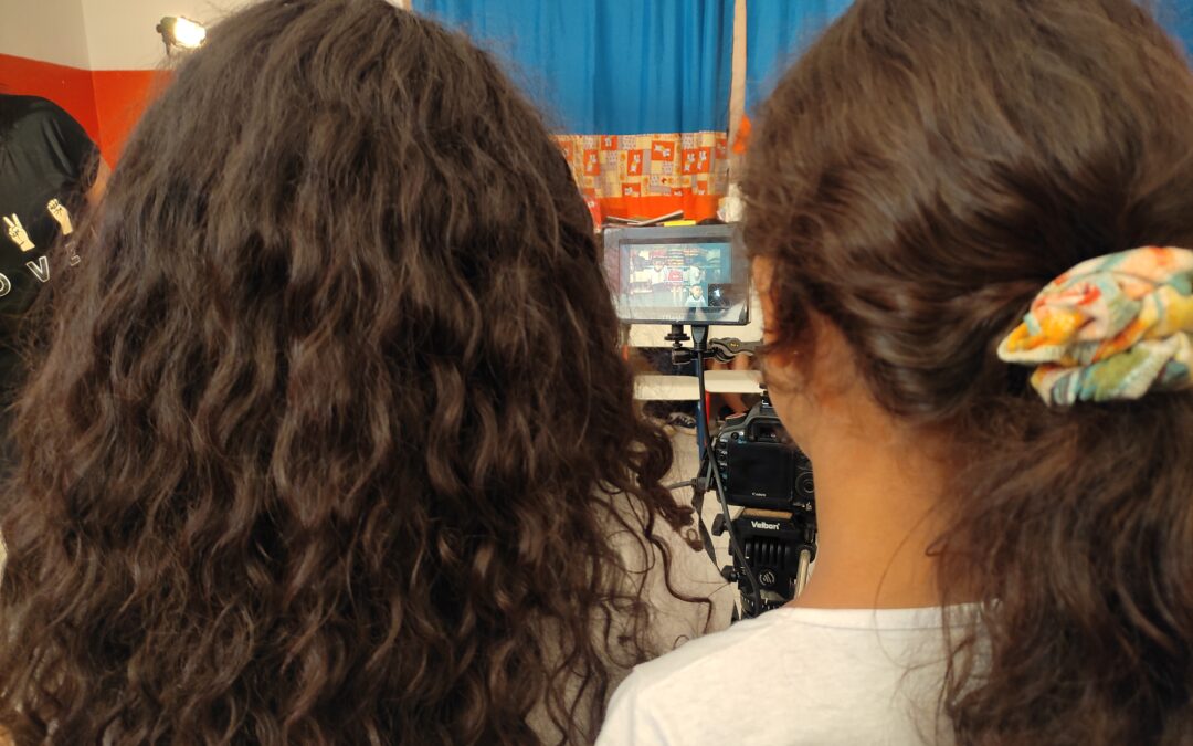 Duas meninas em uma sala de aula olhando para um vídeo-assiste.